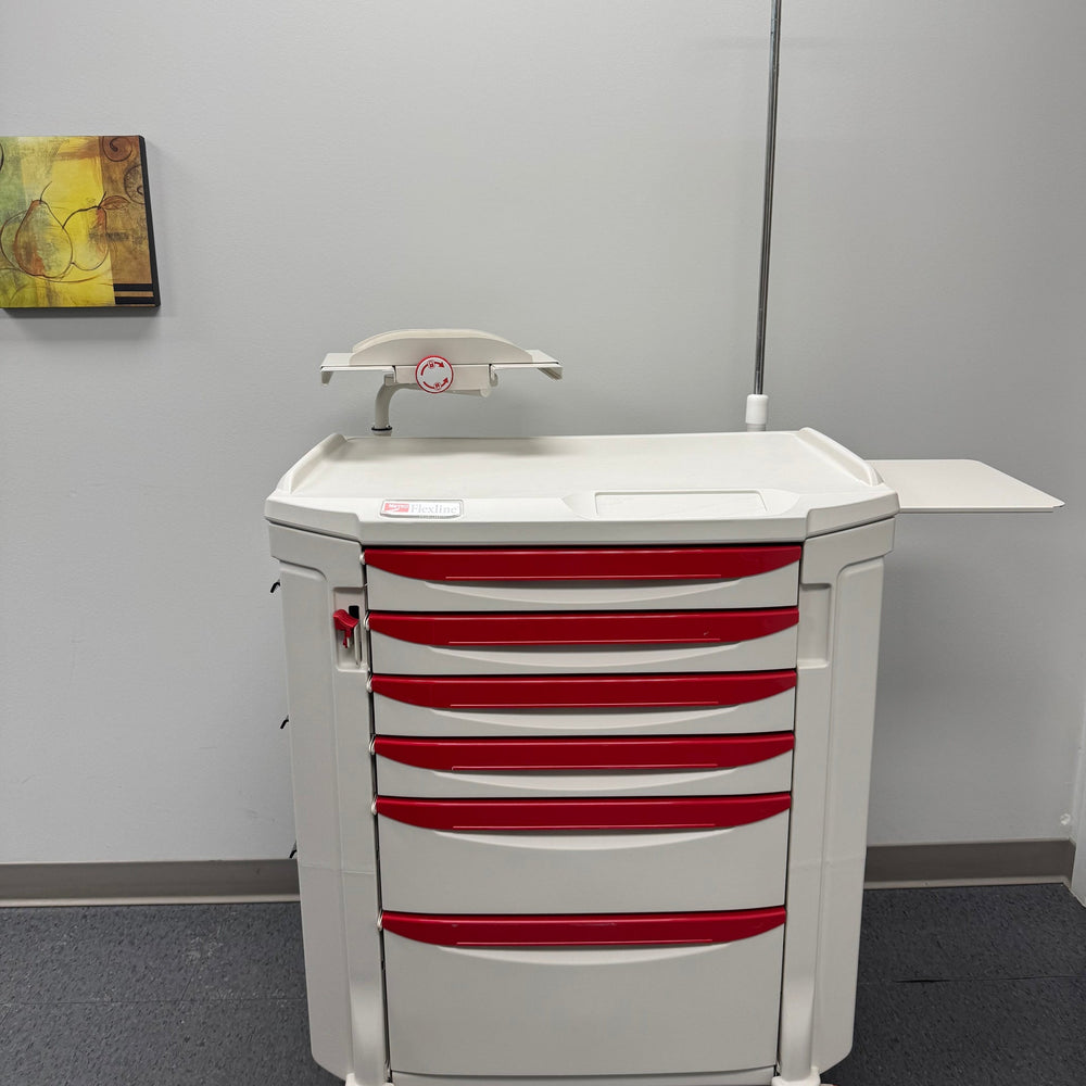 A white and red medical procedure cart with multiple drawers and a worksurface, equipped with a IV pole and lock system, set against a room with a wall painting.